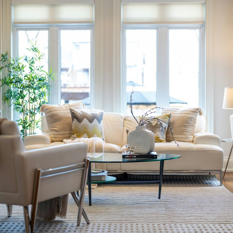 A bright living room with a white sofa under tall windows